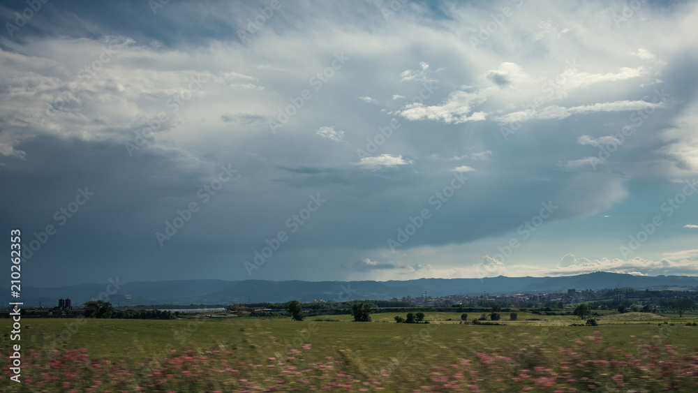 Cloudscape on a green plain field landscape