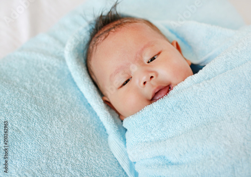 Portrait of cute infant baby boy in towel.