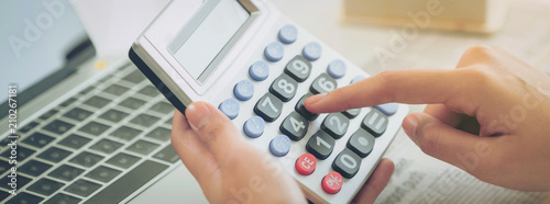 Woman accountant or bank worker uses calculator.