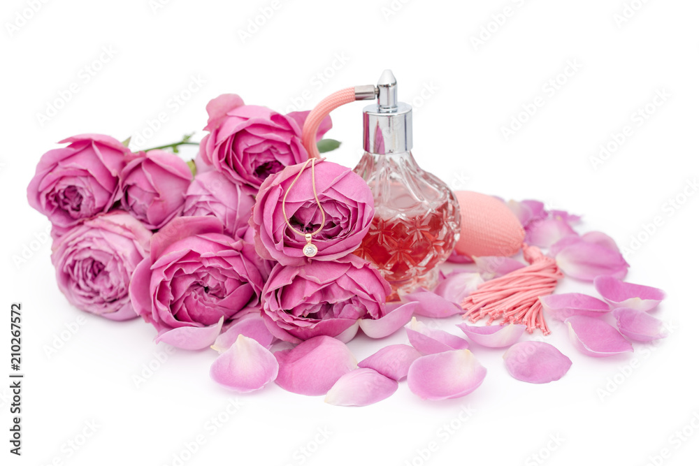 Perfume bottle with golden necklace among flowers on white background. Perfumery, cosmetics, fragrance collection Perfume bottle with golden necklace among flowers on white background. Perfumery, cosmetics, fragrance collection