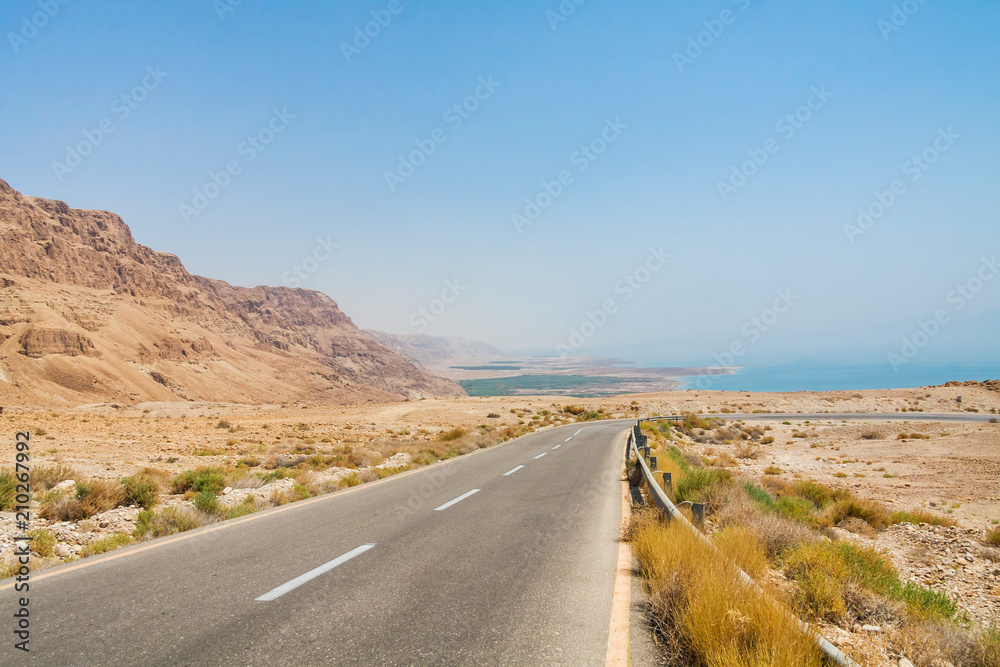 Steep turn of descend highway in Judean desert with Dead Sea in background. Metzoke Dragot, Israel.