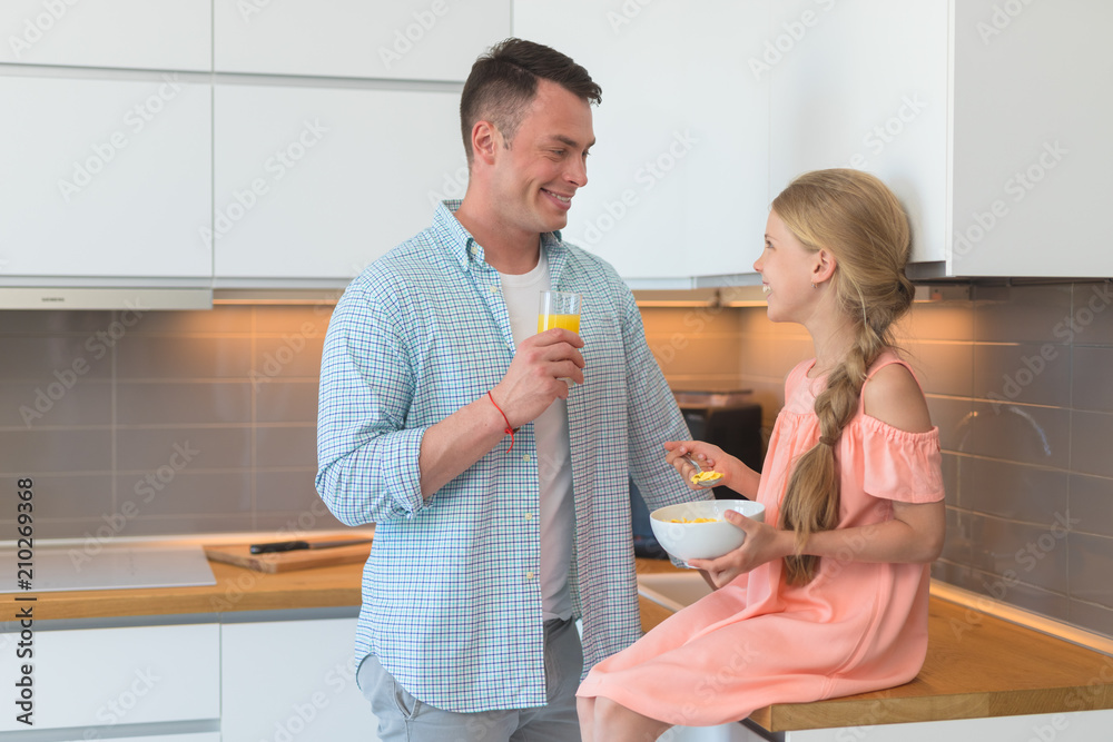 Young father and a little daughter have a breakfast