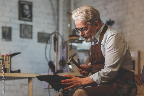 An elderly shoemaker in a workshop photo