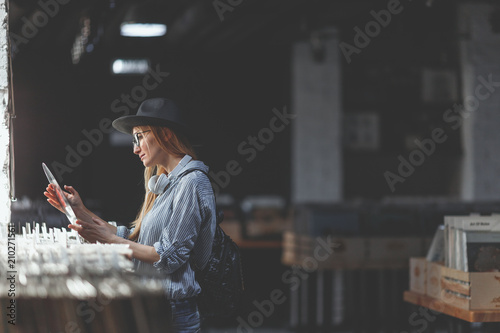 Tapeta Young woman browsing vinyl records indoors