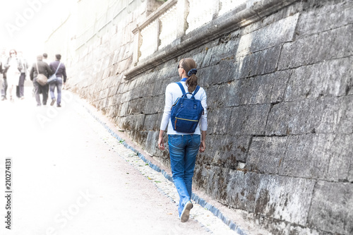 A beautiful woman with a backpack is watching the sights in the city. The concept of travel.