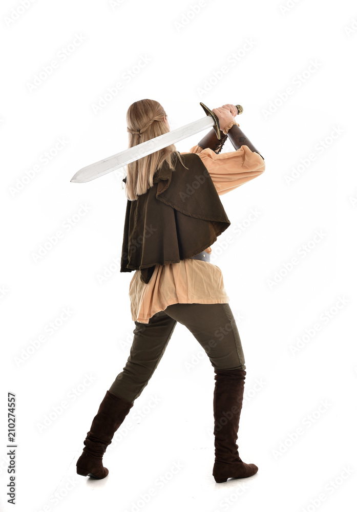 full length portrait of girl wearing medieval costume with sword. standing pose with back to the camera, isolated on white studio background. full length portrait of girl wearing medieval costume with sword. standing pose with back to the camera, isolated on white studio background.