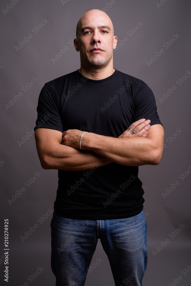 Handsome bald man against gray background Handsome bald man against gray background