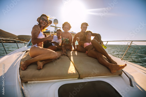Group of friends sitting on the yacht deck with drinks © Jacob Lund