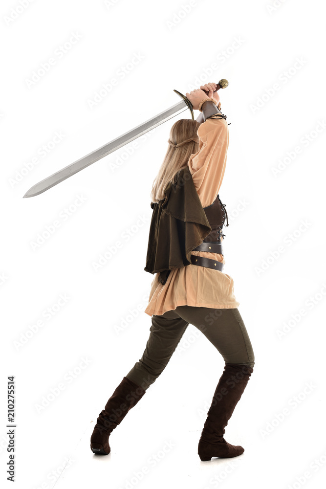 full length portrait of girl wearing medieval costume with sword. standing pose with back to the camera, isolated on white studio background. full length portrait of girl wearing medieval costume with sword. standing pose with back to the camera, isolated on white studio background.