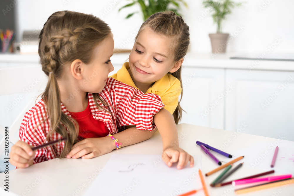 portrait of cute little children at table with papers and pencils for drawing at home portrait of cute little children at table with papers and pencils for drawing at home