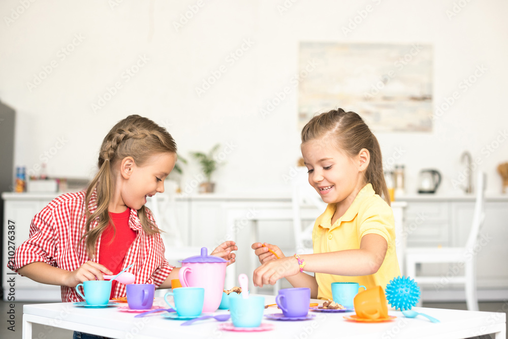 cute little sisters pretending to have tea party together at home cute little sisters pretending to have tea party together at home