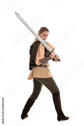 full length portrait of girl wearing medieval costume with sword. standing pose with back to the camera, isolated on white studio background. © faestock