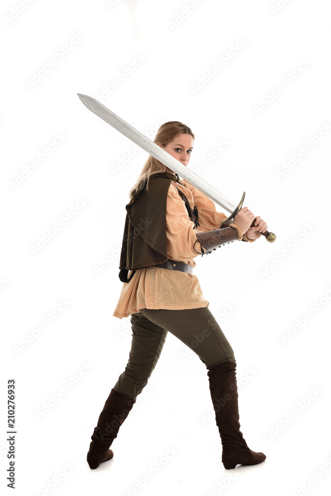 full length portrait of girl wearing medieval costume with sword. standing pose with back to the camera, isolated on white studio background. full length portrait of girl wearing medieval costume with sword. standing pose with back to the camera, isolated on white studio background.