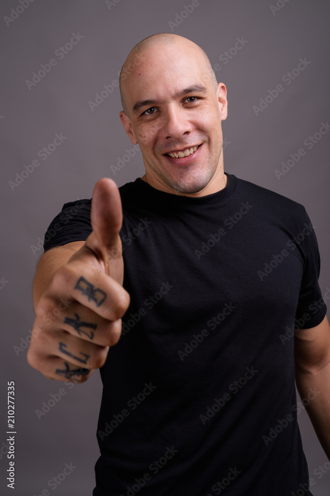 Handsome bald man against gray background Handsome bald man against gray background