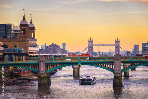 Orange sunset with London cityscape, including Southwark bridge, Cannon Street railway bridge and Tower bridge