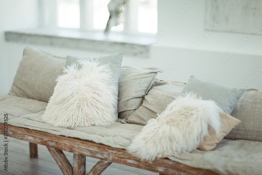 A self-made sofa with light soft pillows in a light-white interior