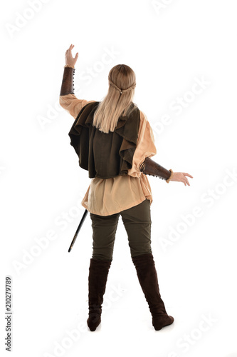 full length portrait of girl wearing medieval costume with sword. standing pose with back to the camera, isolated on white studio background.