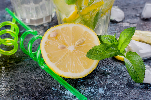 Glass of a cold mojito, juicy slised lemon and mint photo