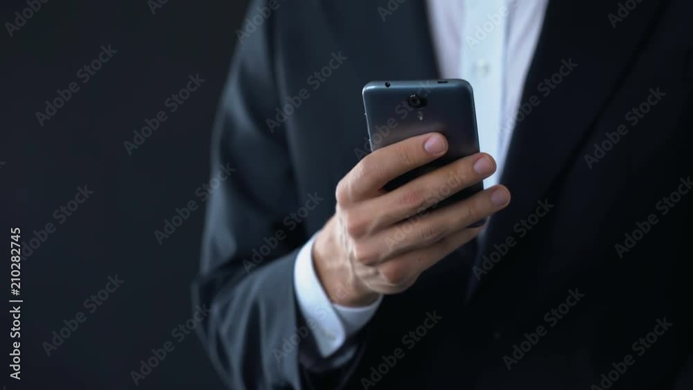 Businessman checking meeting calendar online, texting message on smartphone