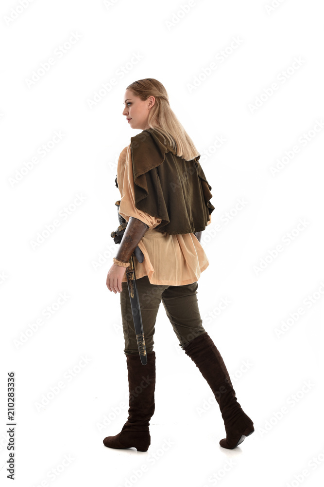 full length portrait of girl wearing medieval costume with sword. standing pose with back to the camera, isolated on white studio background. full length portrait of girl wearing medieval costume with sword. standing pose with back to the camera, isolated on white studio background.