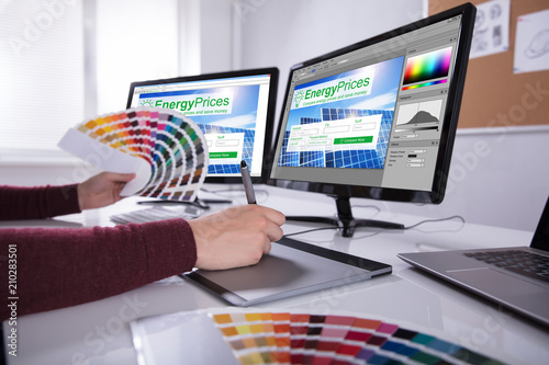 Designer Working On Multiple Computer Screens