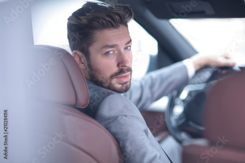 Successful man sitting behind the wheel of a prestigious car