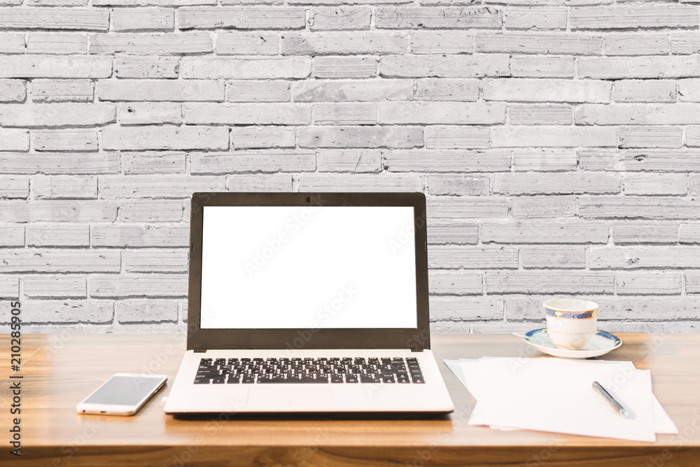 Mockup image of laptop with blank white screen,smartphone,coffee cup on wooden table of coffee wall large texture background. Mockup image of laptop with blank white screen,smartphone,coffee cup on wooden table of coffee wall large texture background.