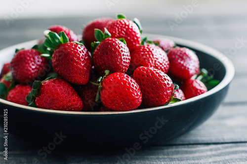 Strawberries in a bowl on a wooden table