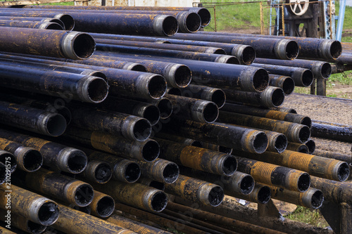 Oil Drill pipe. Rusty drill pipes were drilled in the well section. Downhole drilling rig. Laying the pipe on the deck. View of the shell of drill pipes laid in courtyard of the oil and gas warehouse.