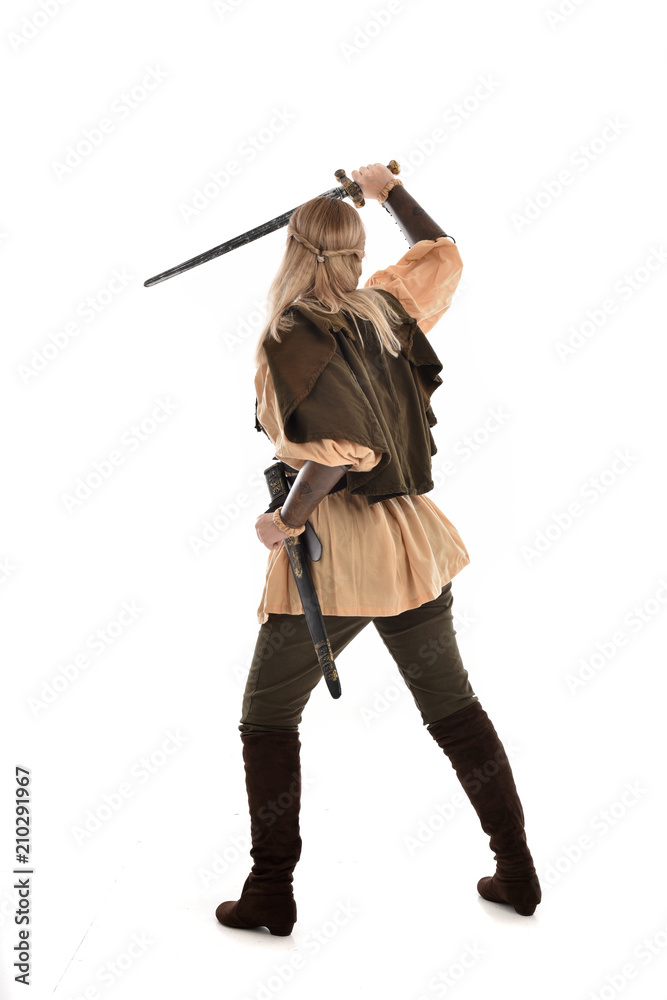 full length portrait of girl wearing medieval costume with sword. standing pose with back to the camera, isolated on white studio background. full length portrait of girl wearing medieval costume with sword. standing pose with back to the camera, isolated on white studio background.