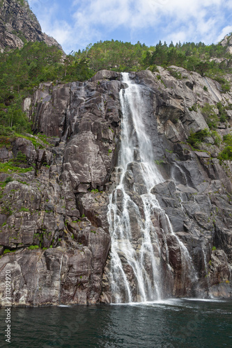 Water falls from steep rocks and disperse into spray veil on the mountain slopes beside Lysefjord  Rogaland  Norway