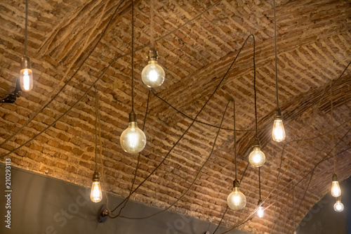 Edison Light bulbs handing from strings on a brick wall