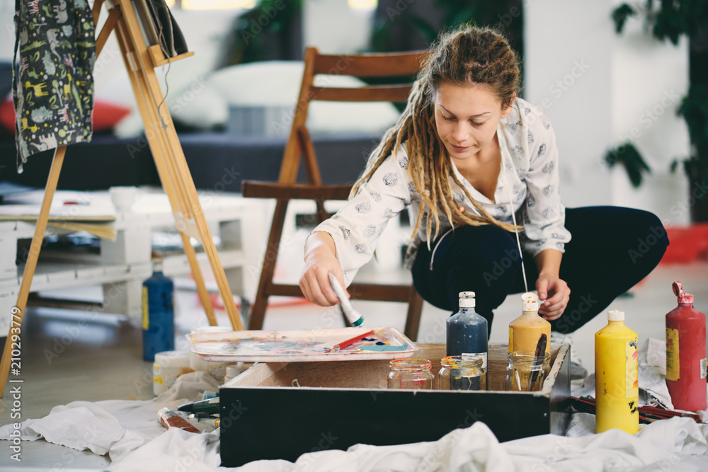 Fototapeta premium Artistic girl mixing colors for painting.