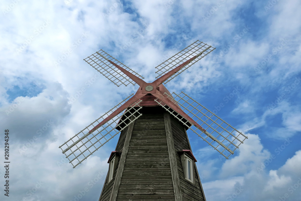 wooden windmill on cloudy sky wooden windmill on cloudy sky