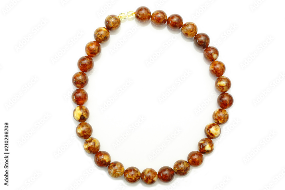 Amber. Beads made from natural yellow brown amber mineral on a white background. Fashionable jewelry amber beads from round and oblong beads. Sun stone as a jeweler raw material. Frozen Resin Fossil Amber. Beads made from natural yellow brown amber mineral on a white background. Fashionable jewelry amber beads from round and oblong beads. Sun stone as a jeweler raw material. Frozen Resin Fossil