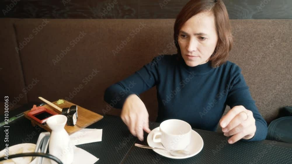 The girl pours the tea into a cup. A woman spills tea from a teapot. The girl pours the tea into a cup. A woman spills tea from a teapot.