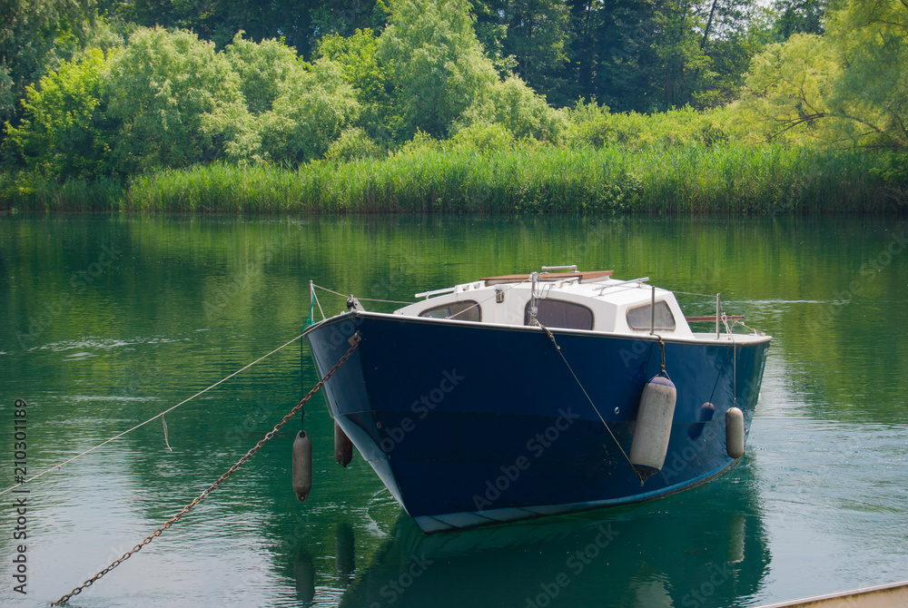 Blue boat for free time in the Adda river Blue boat for free time in the Adda river