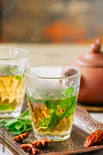 Traditional moroccan mint tea with dates on a vintage tray. White stone background. Close up.