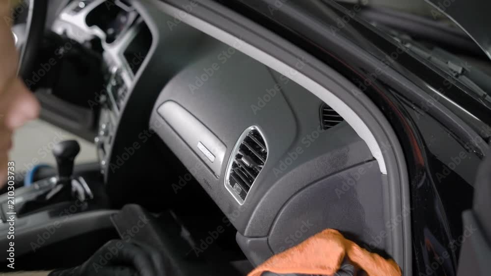 man is rubbing control panel of automobile by cloth, cleaning surface from dirt during washing of interior man is rubbing control panel of automobile by cloth, cleaning surface from dirt during washing of interior