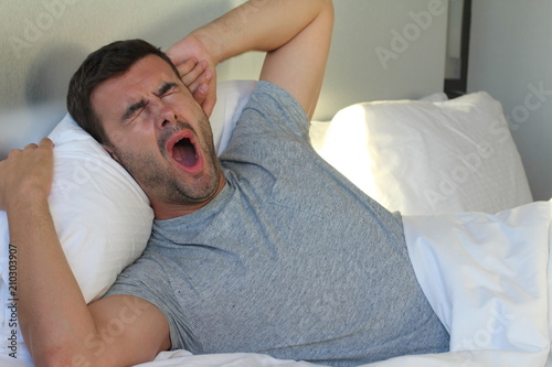 Canvas Print Lazy man yawning in bed