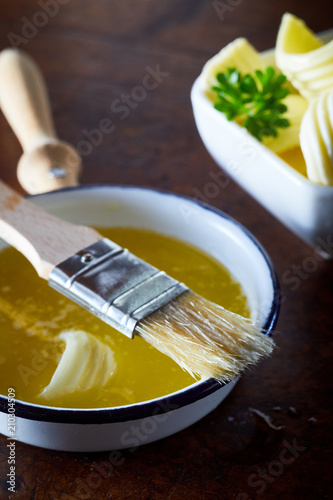 Bowl of melted butter with a basting brush