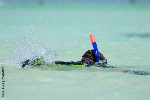 Diving people underwater in sea with corals and fish around, scuba diver open waters beginner course with professional instructor and young kid first time exploring swimming with dolphins with motor