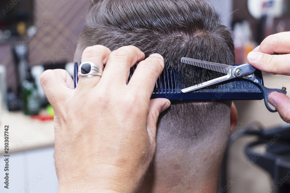 men's hair Styling and grooming with the help of scissors machine and hair  clippers in the hair salon. Stock Photo | Adobe Stock