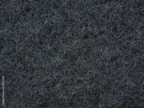 Close-up of dark gray fabric fibrous texture. A plurality of fibers are woven together and form a single surface structure. Good wallpaper or background for many tasks. Macro photography