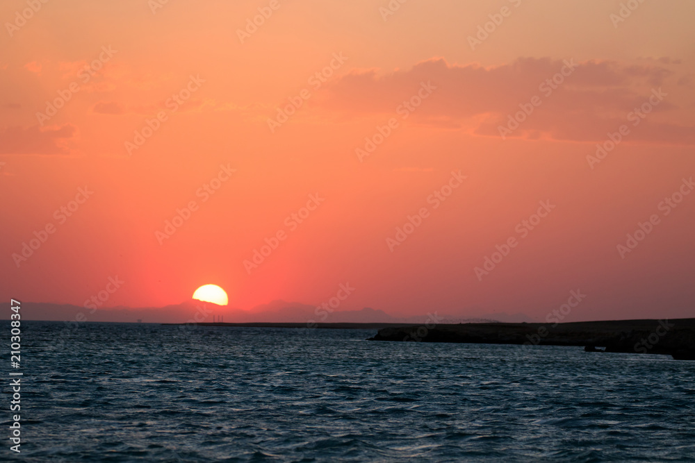 Sunset orange and red colors landscape, sea and sun with deep sky background. Red Sea, Egypt, Africa. Evening sunset view with clouds sky. Vacation at summer time. Sunrise morning beauty of nature
