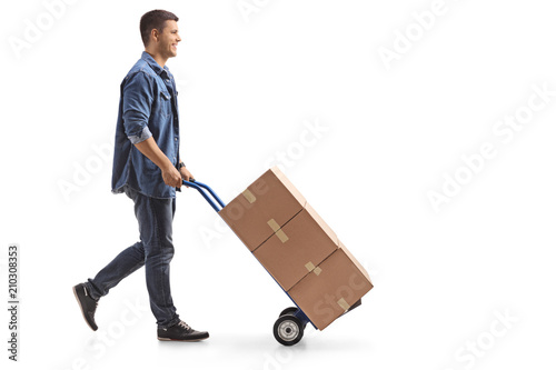 Young man pushing a hand truck with boxes