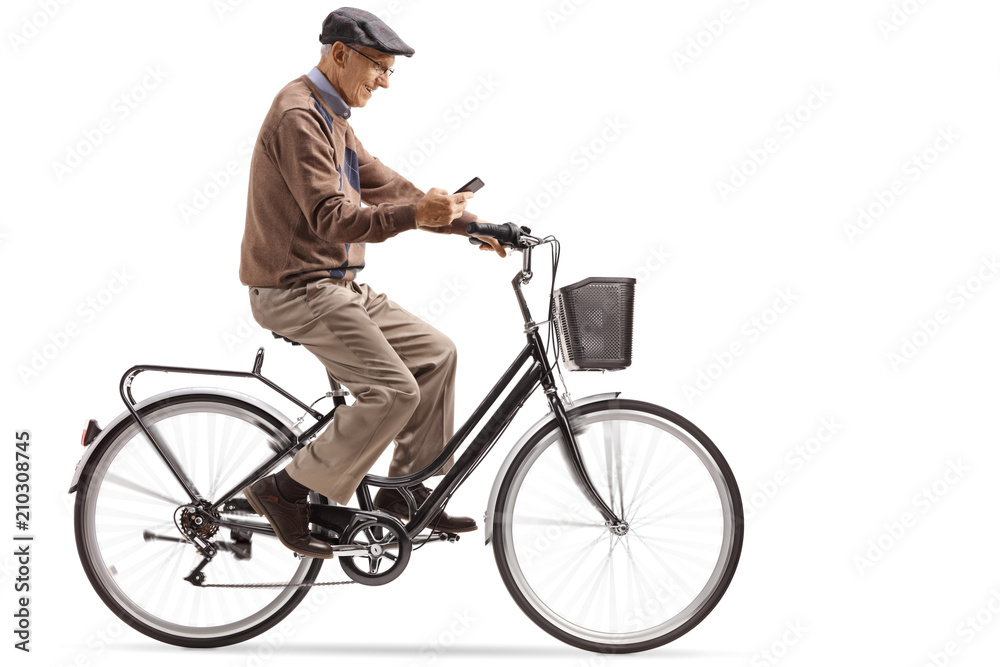 Naklejka premium Senior riding a bike and looking at his phone