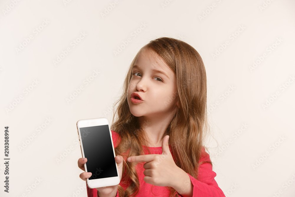The happy teen girl standing and smiling against white background. The happy teen girl standing and smiling against white background.