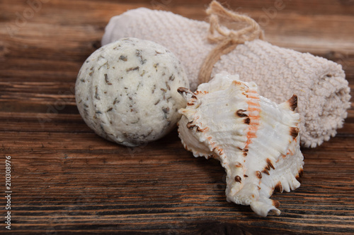 scallop and herbal white bath ball for white towel on a brown background