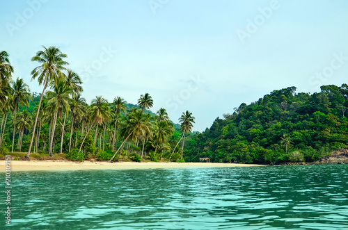 Tropical sandy beach with palm trees and tropical forest. Shooting from the sea. Thailand, Koh Chang Island